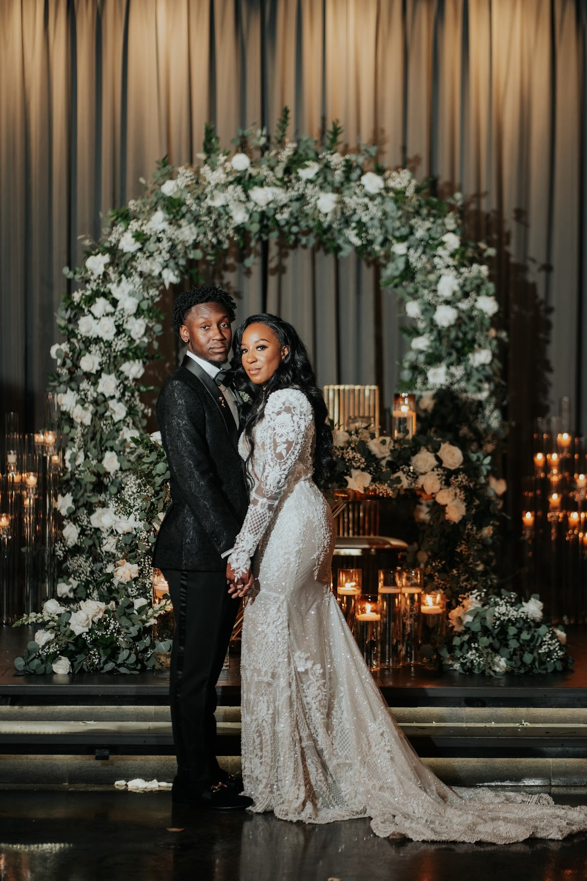 Couple in front of floral arch